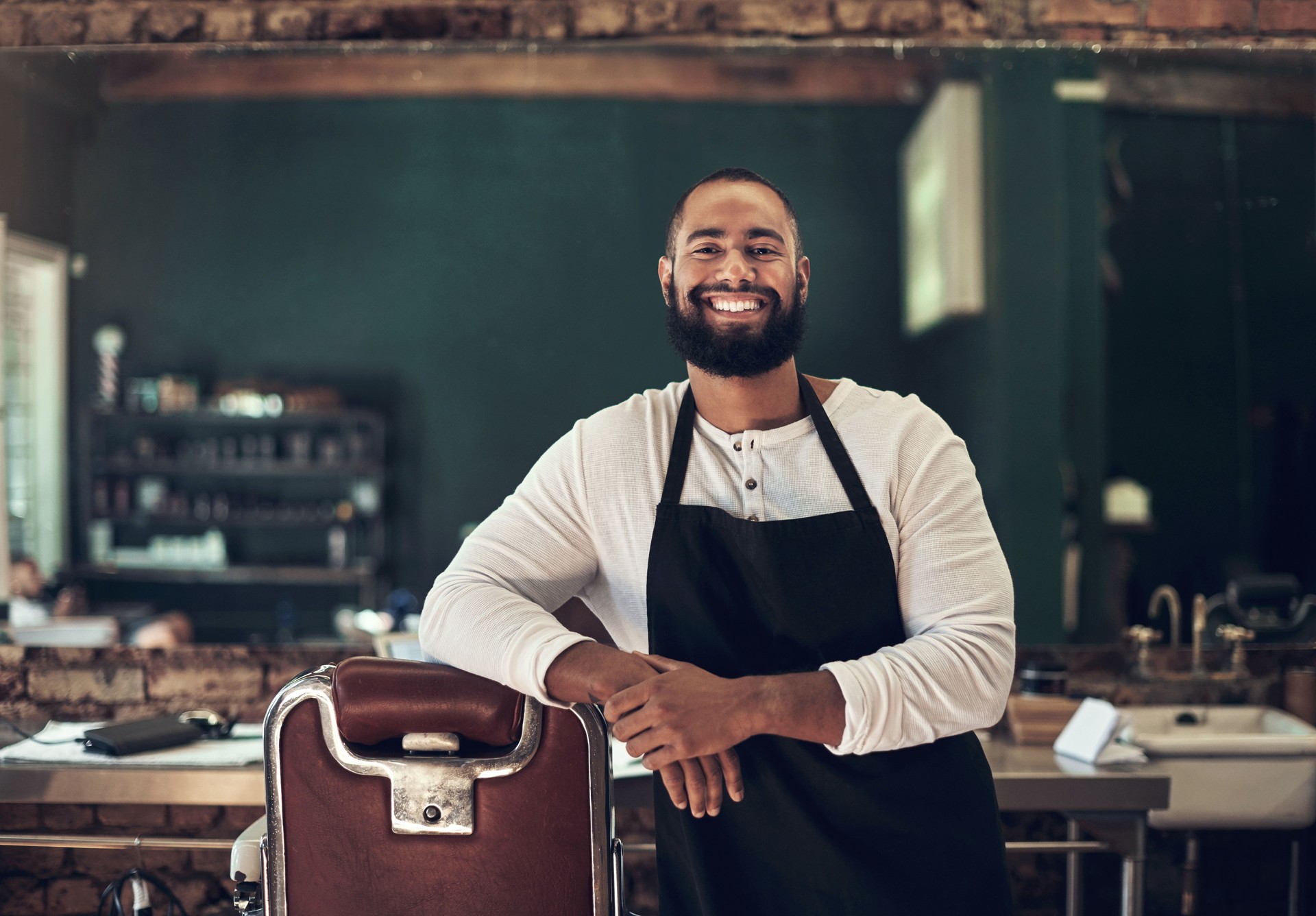 Shot of a handsome young barber standing alone in his salon